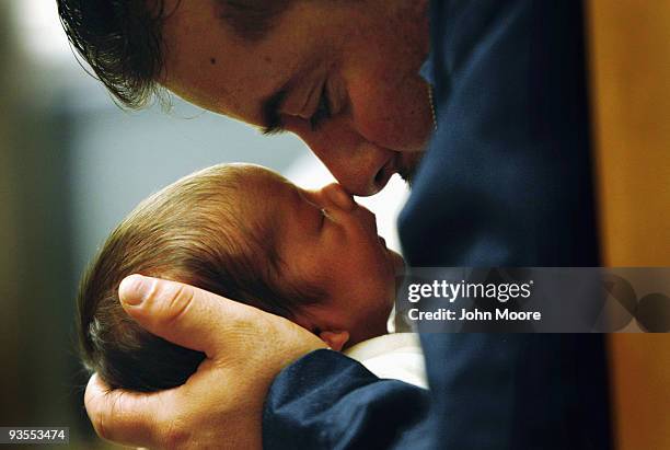 An immigrant from Mexico holds his son during a newborn care class at a community health center for low-income patients on December 1, 2009 in...