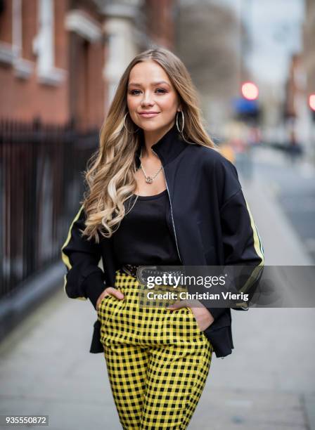 British singer Connie Talbot wearing yellow pants, black top and black jacket, black ankle boots seen during London Fashion Week February 2018 on...