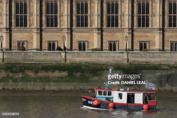 Boat decorated with flags and banners from the pro-Brexit 'Fishing for Leave' sails past Britain's Houses of Parliament to allow fishermen, and...