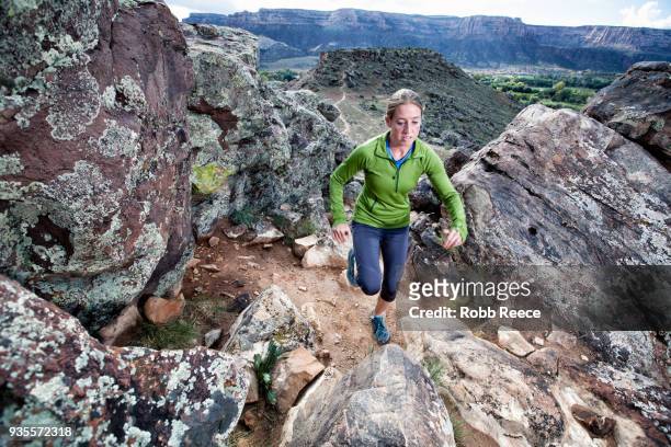 an adult woman trail running on a remote dirt trail - robb reece stock-fotos und bilder