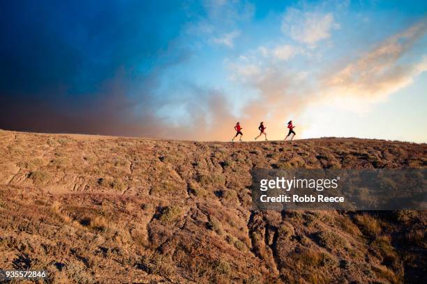 three women trail running in the desert at sunrise - robb reece stock-fotos und bilder