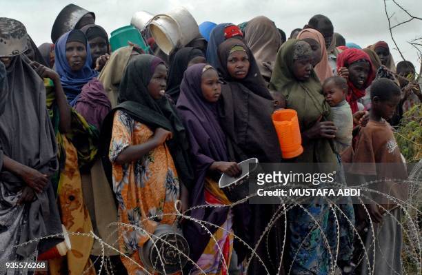 Internally-displaced Somalis wait for food at a distribution point at the government-run Badbaado refugee camp in a suburb of the Somali capital of...