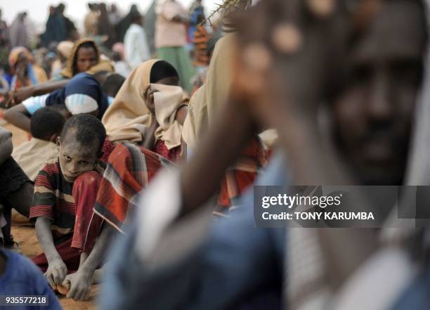 Dusty-faced young Somali boy waits with other Somali refugees lining-up at a registration centre on August 2, 2011 at Dagahaley refugee site within...