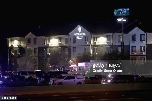 Law enforcement officials investigate at the location where the suspected package bomber was killed in suburban Austin on March 21, 2018 in Round...