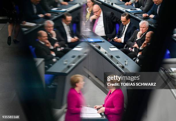 German Chancellor Angela Merkel is reflected as German Finance Minister and Vice-Chancellor Olaf Scholz, Interior Minister Horst Seehofer, Foreign...