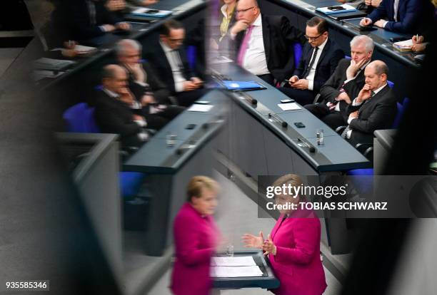German Chancellor Angela Merkel is reflected as German Finance Minister and Vice-Chancellor Olaf Scholz, Interior Minister Horst Seehofer, Foreign...