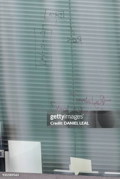 The words "Data" , "Digital" and "Regulations?" are seen written on the window of a second floor office in the shared building which houses the...