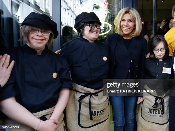 The wife of French President Brigitte Macron poses with handicapped and autistics employees of the Cafe Joyeux restaurant in Paris on March 21, 2018....