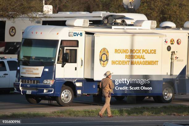 Law enforcement officials search for evidence at the location where the suspected package bomber was killed in suburban Austin on March 21, 2018 in...