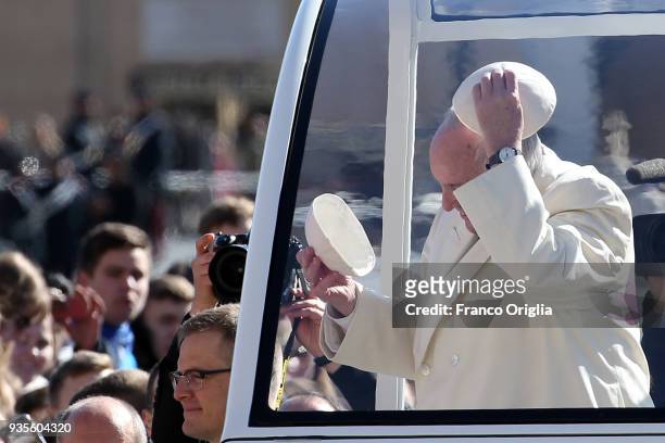 Pope Francis exchanges his biretta cup with a faithful as he arrives in St. Peter's Square for the weekly audience in St. Peter's Square on March 21,...
