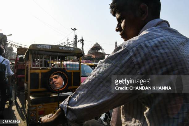 An Indian cycle rickshaw puller rides through a lane in the old quarters of New Delhi on March 21, 2018.