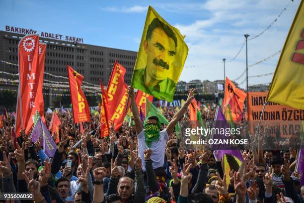 People flash victory sign and wave flags of jailed PKK leader Abdullah Ocalan as part of the Kurdish celebration of Nowruz , the Persian calendar New...