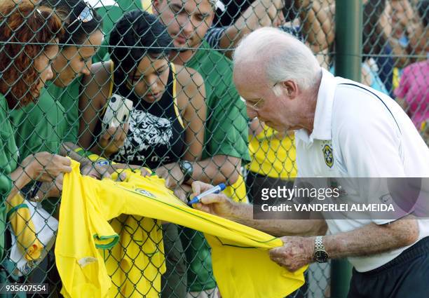 Mario Jorge Lobo Zagalo, supervisor tecnico de la seleccion brasileña de futbol firma autografos en una camiseta del seleccionado de Brasil a...