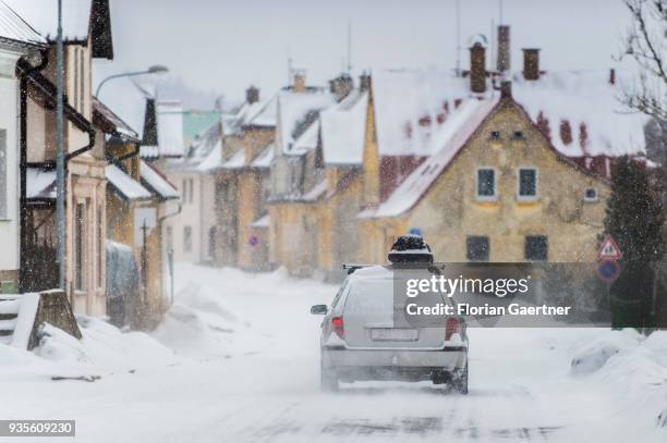 Car with a ski box drives during snow fall on March 17, 2018 in Josefuv Dul, Czech Republic.