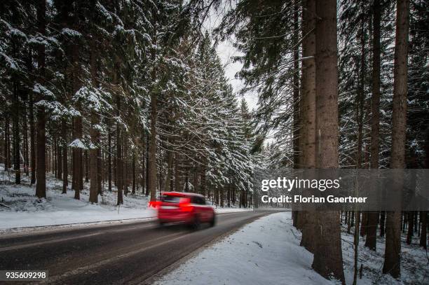 Car drives through a conifer forest at winter on March 17, 2018 in Liberec, Czech Republic.