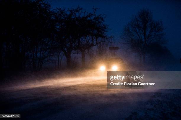 Car drives through a snow storm in the evening on March 17, 2018 in Frydlant, Czech Republic.