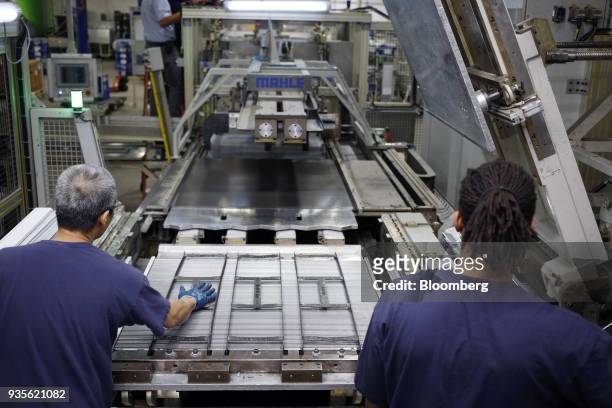 Workers assemble truck engine cooling module components at the MAHLE Behr Charleston Inc. Auto part facility in Charleston, South Carolina, U.S., on...