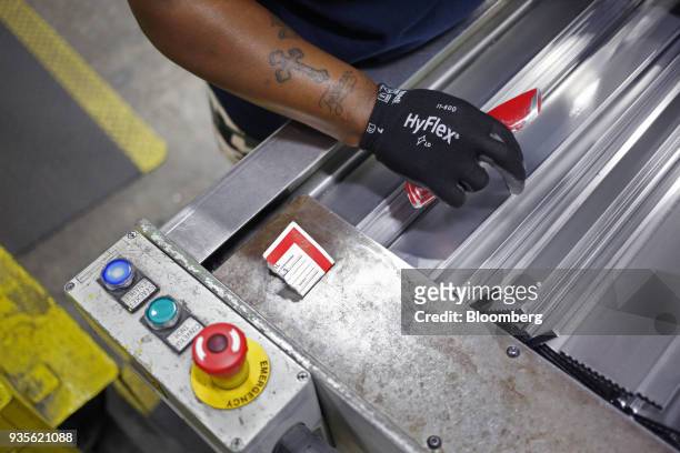 Worker holds a utility knife while assembling truck engine cooling module components at the MAHLE Behr Charleston Inc. Auto part facility in...