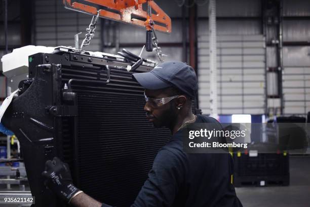 Worker attaches a truck engine cooling module to a shipping rack at the MAHLE Behr Charleston Inc. Auto part facility in Charleston, South Carolina,...