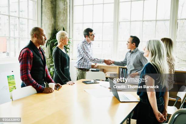 client shaking hands with architect after planning meeting in design office - design studio woman chinese laptop fotografías e imágenes de stock