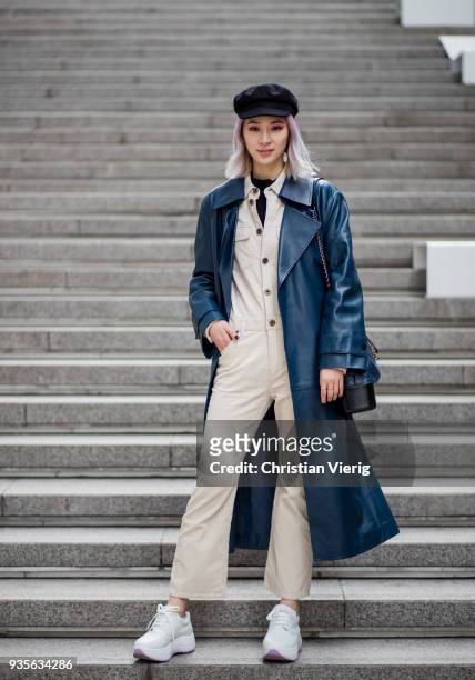 Irene Kim wearing flat cap, navy vinyl leather coat, Chanel bag, beige overall is seen at the Hera Seoul Fashion Week 2018 F/W at Dongdaemun Design...