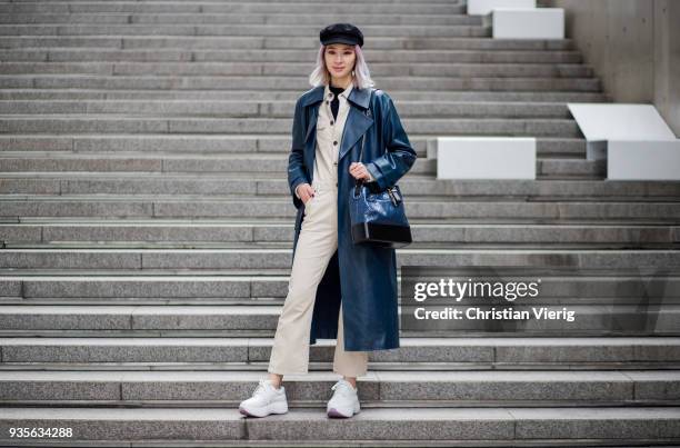 Irene Kim wearing flat cap, navy vinyl leather coat, Chanel bag, beige overall is seen at the Hera Seoul Fashion Week 2018 F/W at Dongdaemun Design...