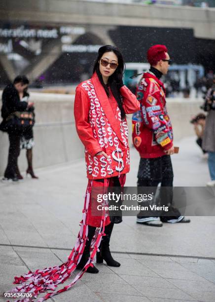 Guest wearing red leather jacket with dollar print is seen at the Hera Seoul Fashion Week 2018 F/W at Dongdaemun Design Plaza on March 21, 2018 in...