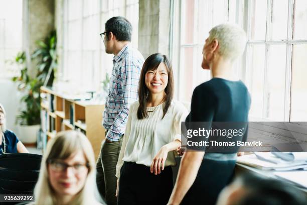 smiling coworkers in discussion in design studio - freundschaftliche verbundenheit stock-fotos und bilder