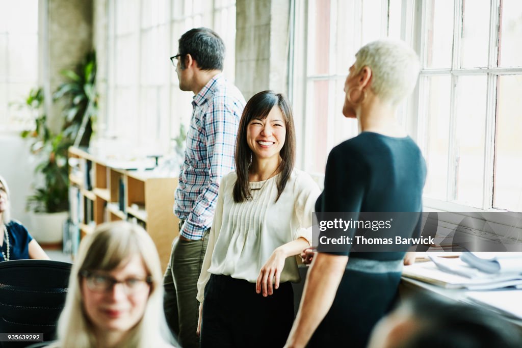 Smiling coworkers in discussion in design studio