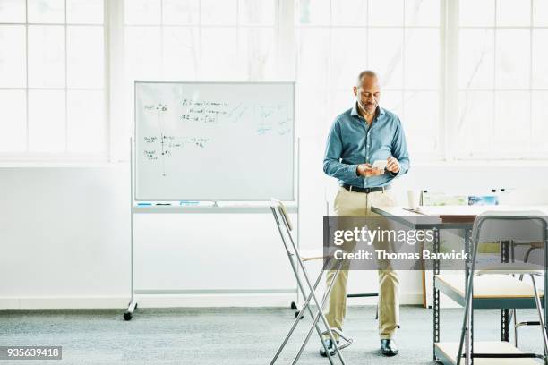 businessman working on smartphone in design studio - smart shoes stock pictures, royalty-free photos & images