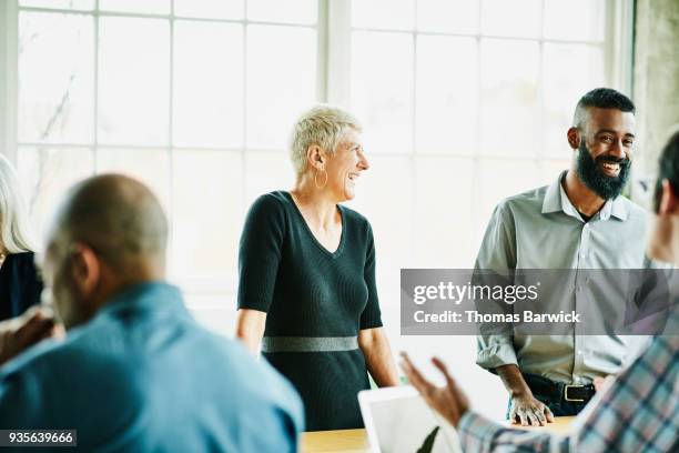 laughing architects in design planning meeting in office conference room - first gray hair stock pictures, royalty-free photos & images