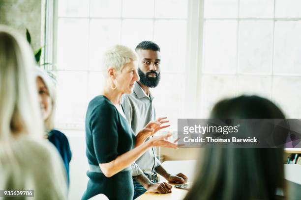businessman listening to colleague present during project planning meeting in office - collaborate whiteboard stock pictures, royalty-free photos & images