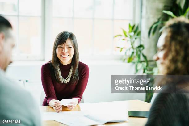 smiling businesswoman in meeting with clients in office conference room - women in transparent clothing fotografías e imágenes de stock