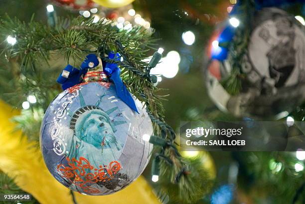 An ornament with the Statue of Liberty hangs on the official White House Christmas tree in the Blue Room of the White House during a press tour of...