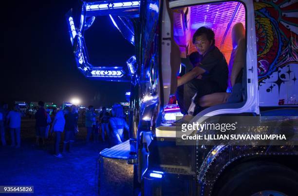 This photograph taken on December 23, 2017 shows a driver sitting inside his custom-painted truck at a fancy truck party in the Thai coastal province...