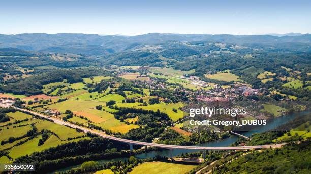 aerial view of beautiful french countryside with elevated highway small village and beginning of alps mountains in background - rhone alpes stock pictures, royalty-free photos & images