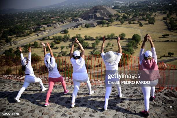 Women atop the Pyramid of the Sun at the archaeological site of Teotihuacan, in the municipality of Teotihuacan, northeast of Mexico City, stretch...