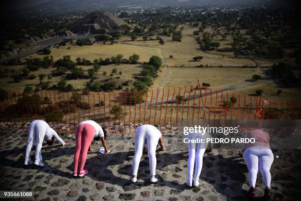 Women atop the Pyramid of the Sun at the archaeological site of Teotihuacan, in the municipality of Teotihuacan, northeast of Mexico City, stretch...