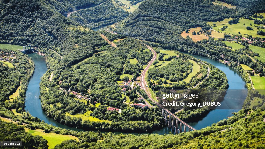 Aerial view of french Ain river valley in horseshoe shape with beautiful old stone viaduct of Cize-Bolozon in Bugey mountains