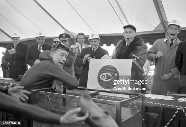 Mouths are agape as a cod fish slips away from Richard Vahan, L, that was intended to go into tank and set off electronically, work on the new...