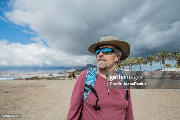 senior man exploring tenerife beach playa de las americas - playa de las americas stock pictures, royalty-free photos & images