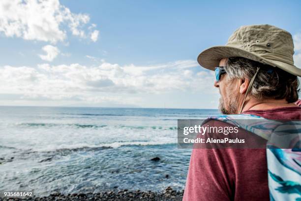 senior man exploring tenerife beach playa de las americas - playa de las americas stock pictures, royalty-free photos & images