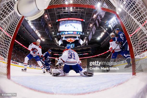 Charlie Lindgren, Jacob de la Rose, and Noah Juulsen of the Montreal Canadiens guard the net against James van Riemsdyk of the Toronto Maple Leafs...