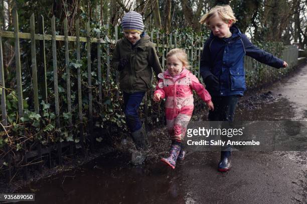 three children walking together - brother sister shower stock-fotos und bilder