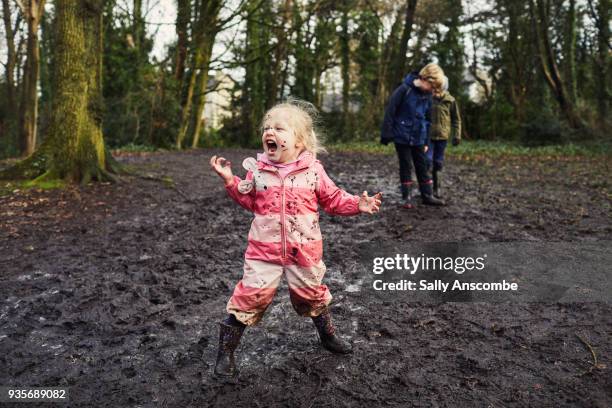 child playing outdoors with mud on her face - familie vor wald stock-fotos und bilder