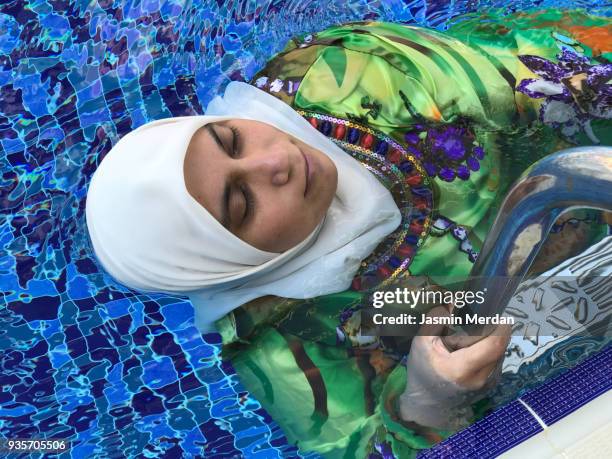 arabian woman in pool - burkini bildbanksfoton och bilder