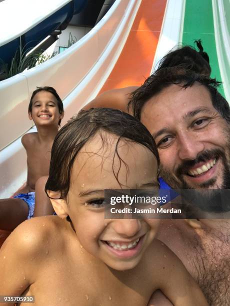 kids sliding into pool aerial view - family sports centre laughing stock pictures, royalty-free photos & images