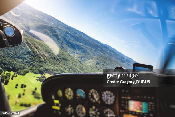 small airplane cockpit interior in selective focus with control instrument panel and hilly landscape background in summer - small plane stock pictures, royalty-free photos & images