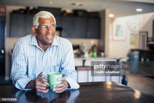 senior black man enjoying a cup of coffee at home - morning kitchen stock pictures, royalty-free photos & images