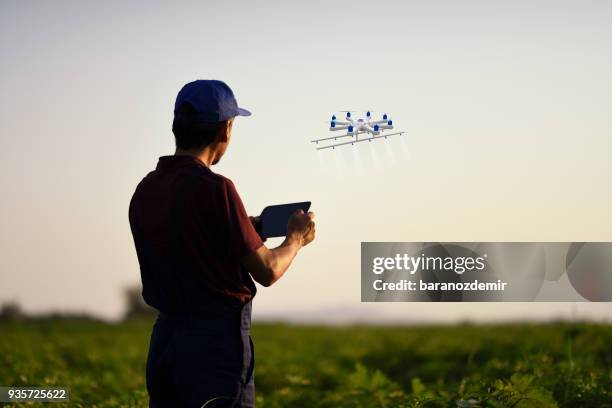 farmer spraying his crops using a drone - drone stock pictures, royalty-free photos & images